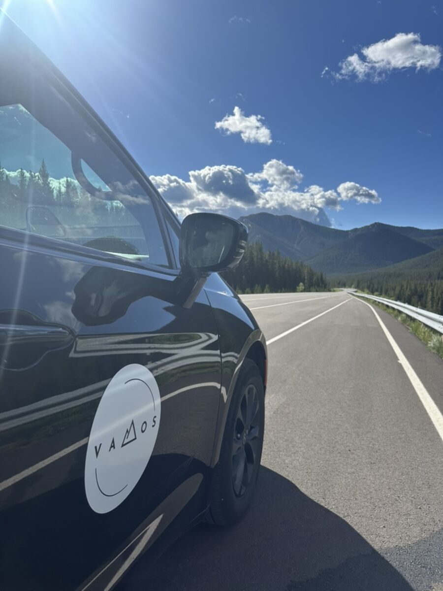 Vamos Express Banff airport shuttle driving toward the Rocky Mountains