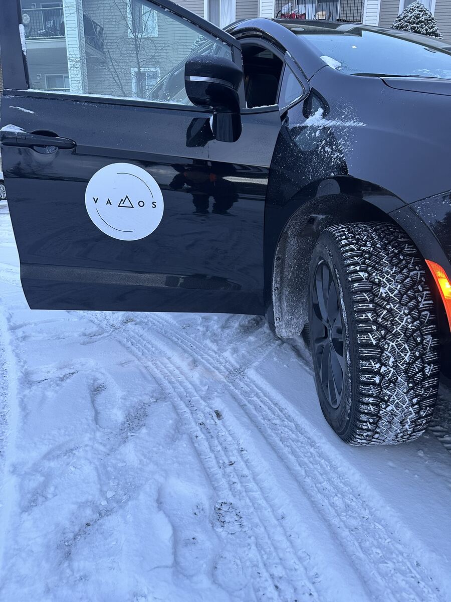 Studded winter tires on the Banff to Calgary Airport shuttle minivan in snow